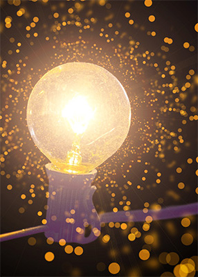 A lightbulb with bokeh, representative of the one-on-one creativity coaching that Jessica Kavanagh provides.